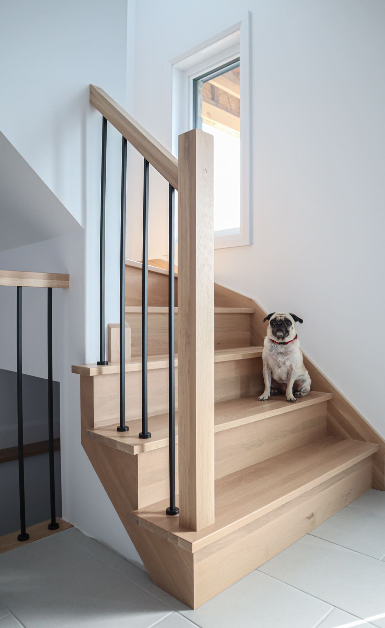 Escalier en chêne blanc, barreaux en fer forgé noir urbain