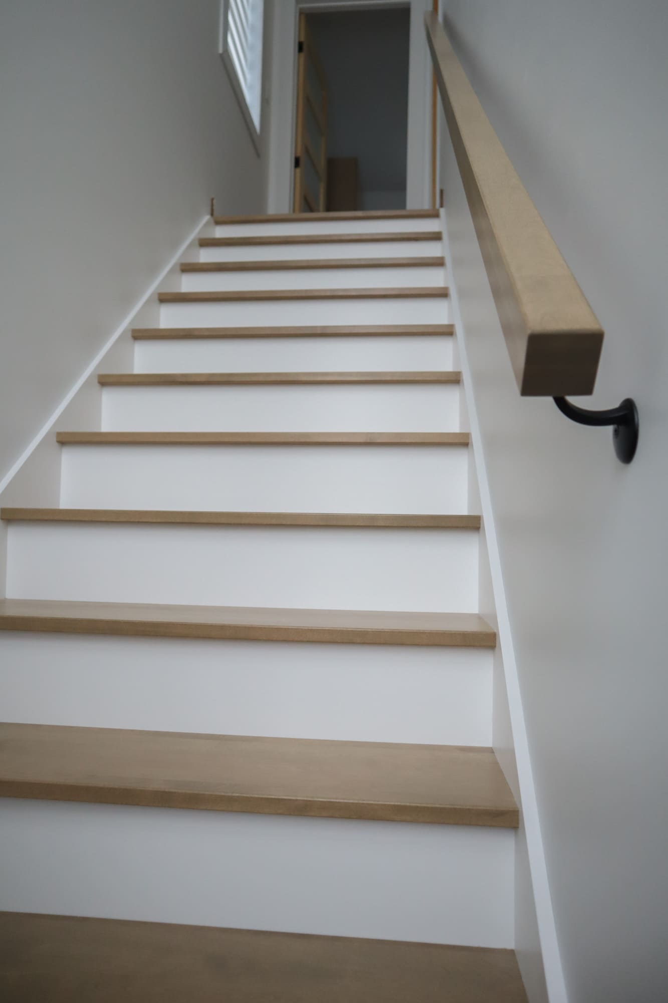 Escalier en merisier naturel, contre-marches et limons laqués blancs