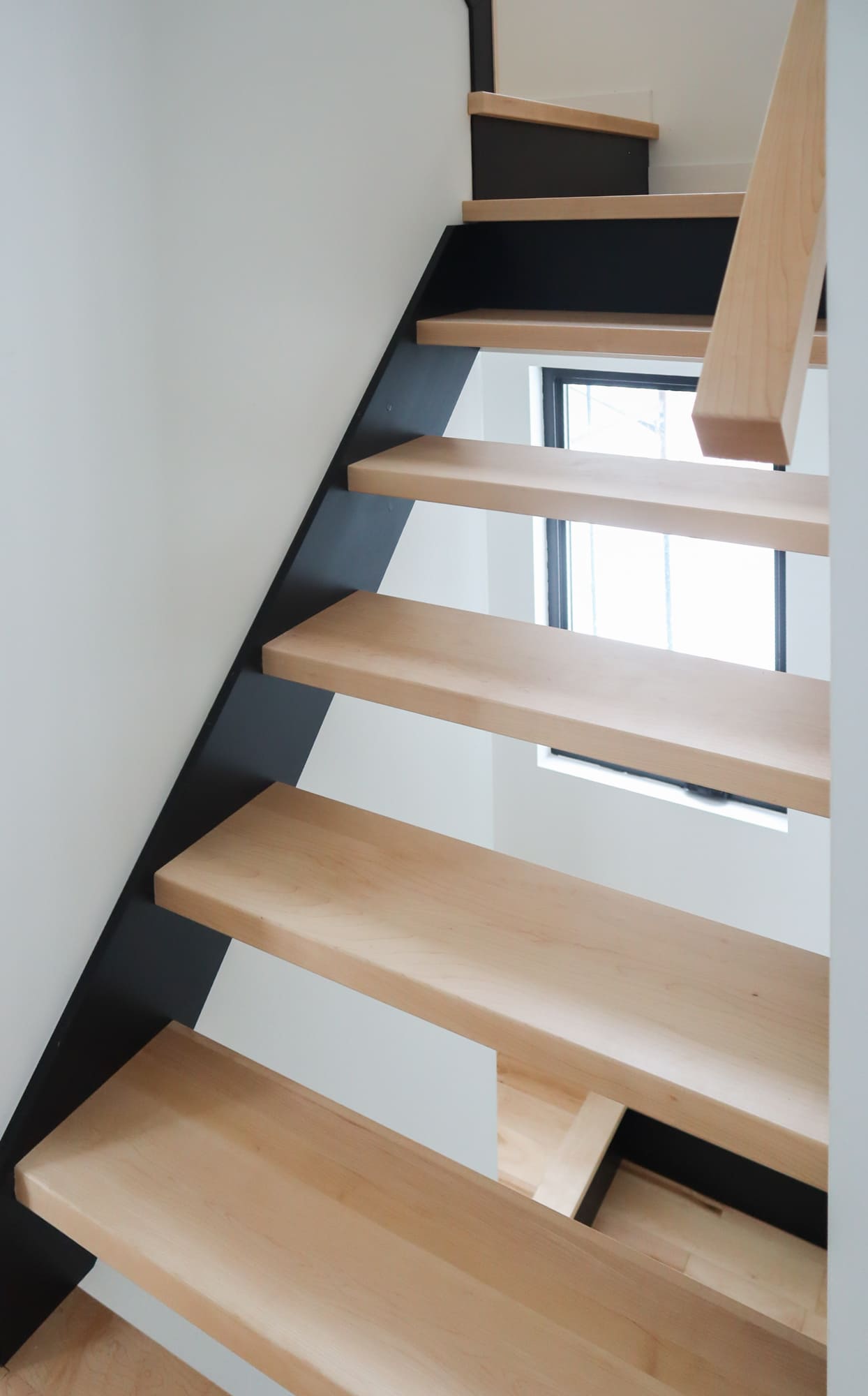 Escalier ouvert en érable naturel, limons laqués noirs